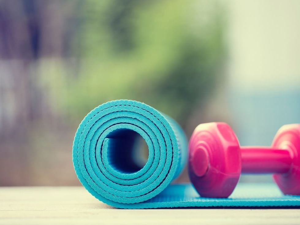 A yoga mat & dumbbell in the Fitness Center at The Abidah Hotel