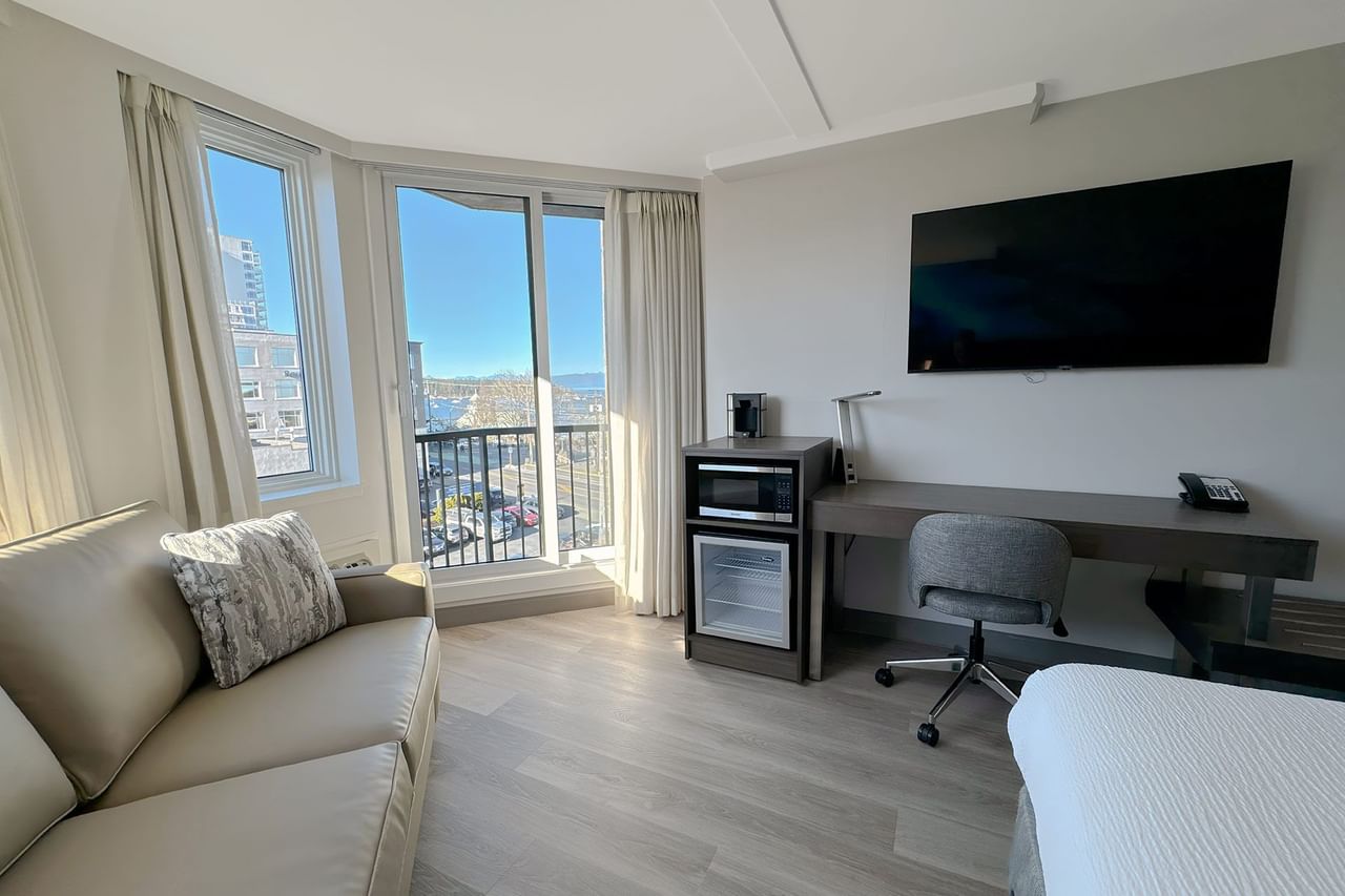 Accessible hotel guestroom with desk, mini fridge and sofa