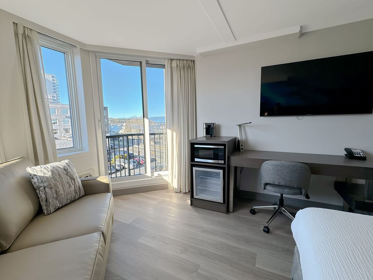 Hotel guestroom with desk, mini fridge and sofa