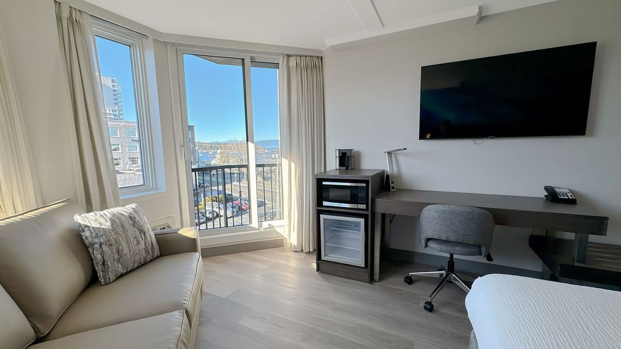Hotel guestroom with desk, mini fridge and sofa