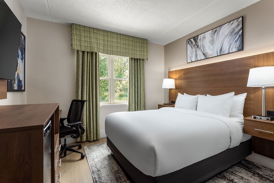 TV with work desk facing bed by window in 1 Queen Bed Mobility Accessible Heritage Room at Spencer Hotel