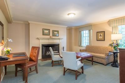 Living area with plush seating and work desk in the Fireplace suite at The Exeter Inn