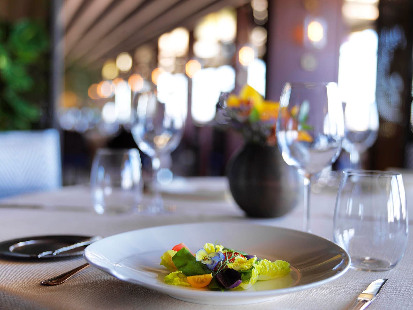 Evergreen Area dining space with wooden tables and chairs, surrounded by lush green at CVK Park Bosphorus Hotel Istanbul