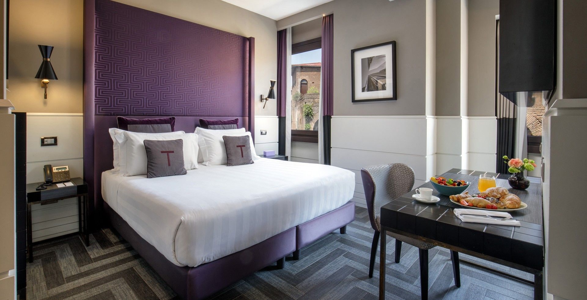 King Bed Room at Tribune Hotel Rome with elegant modern décor, comfortable king bed, work desk, flat-screen TV, and large windows overlooking historic city views.