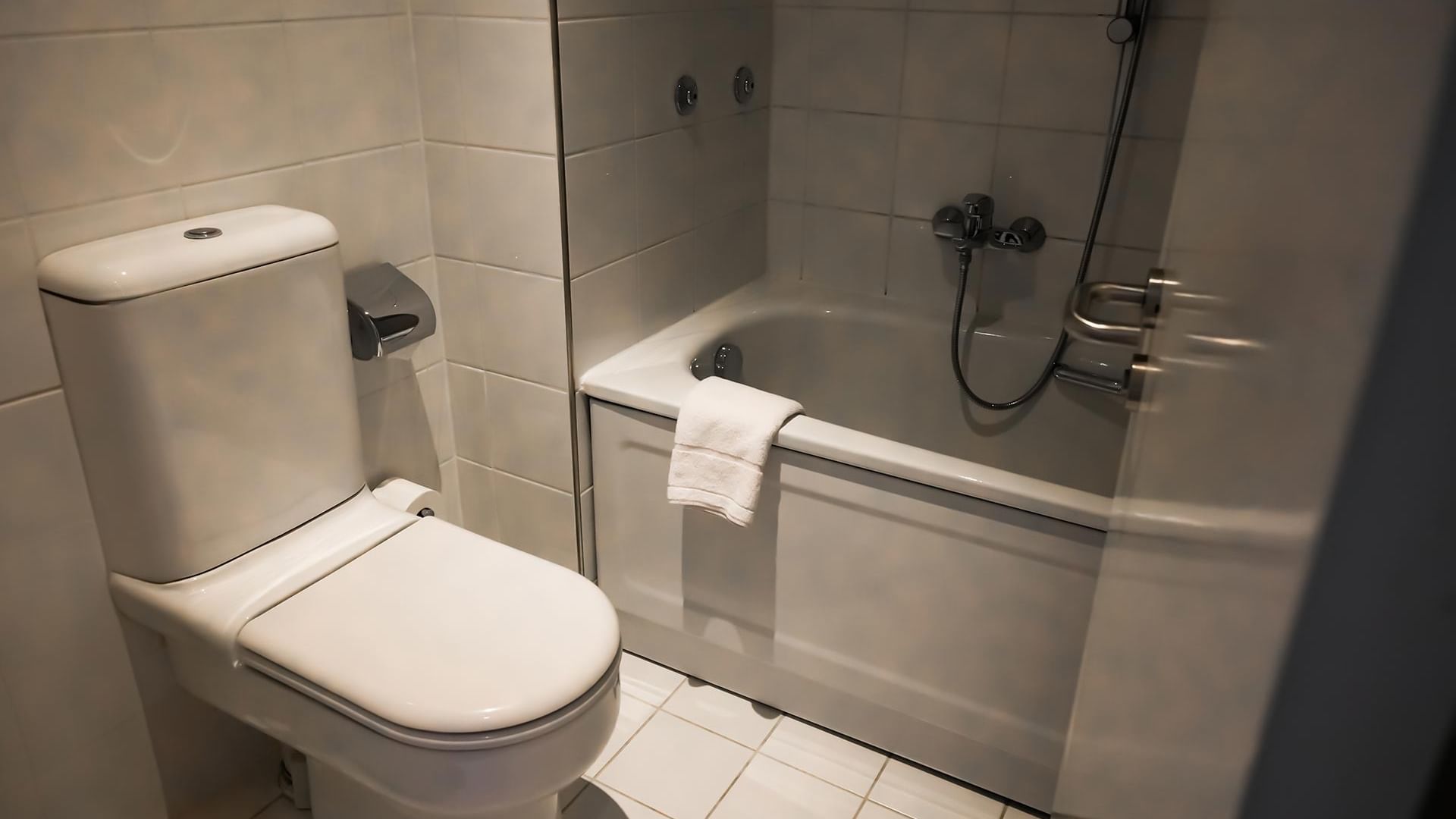 Badezimmer mit Toilette und Badewanne im Standard Doppelzimmer im Sylter Hof Berlin.