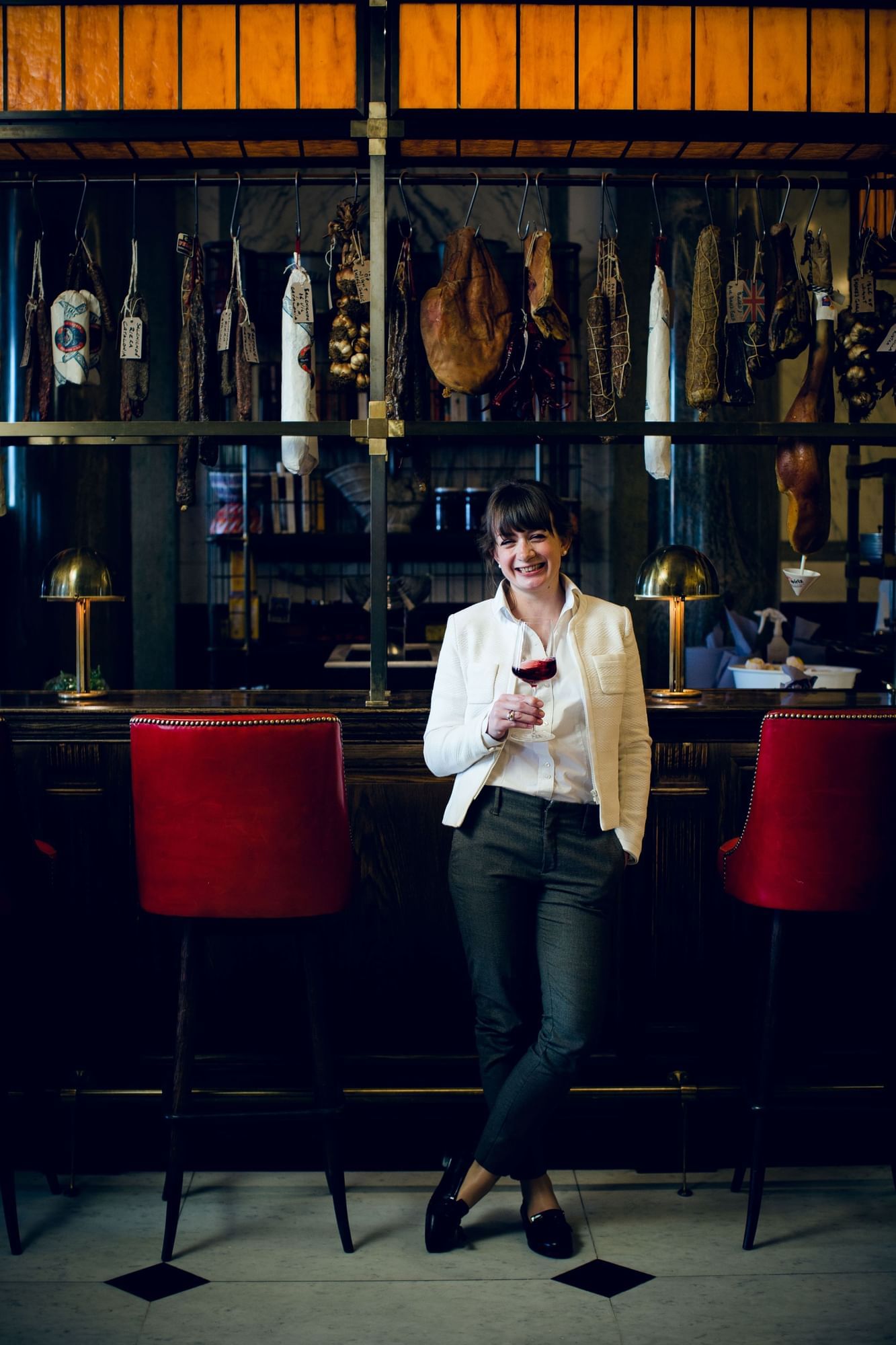 Laura Rhyns, a sommelier holding a wine glass in a bar at The Londoner