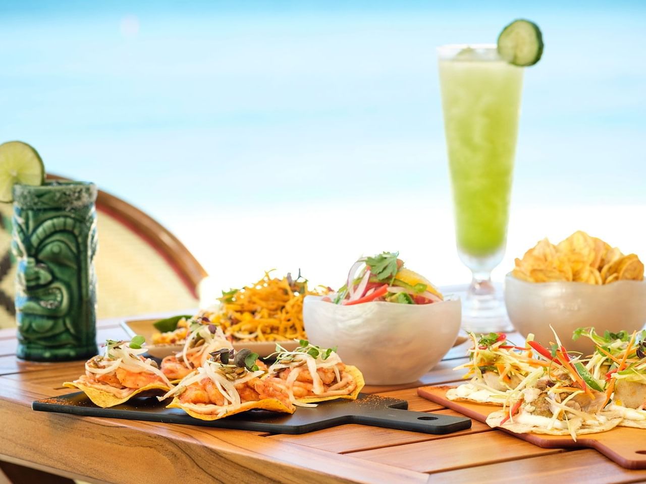 Beachside table featuring shrimp tacos, fresh salads, plantain chips & cocktails in Coccoloba, The Residences at Seafire.