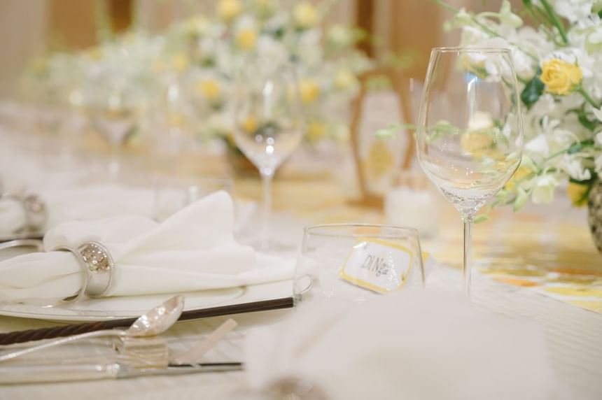 Beautifully arranged dining table with elegant white napkins, crystal glasses, and floral centerpieces at Park Hyatt Saigon