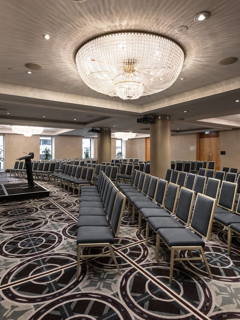 Brisbane room conference space with theater-style seating, crystal chandelier and presentation screen