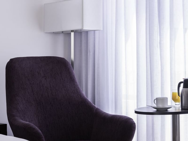 A single lounge chair by the window in a room at Fiesta Inn