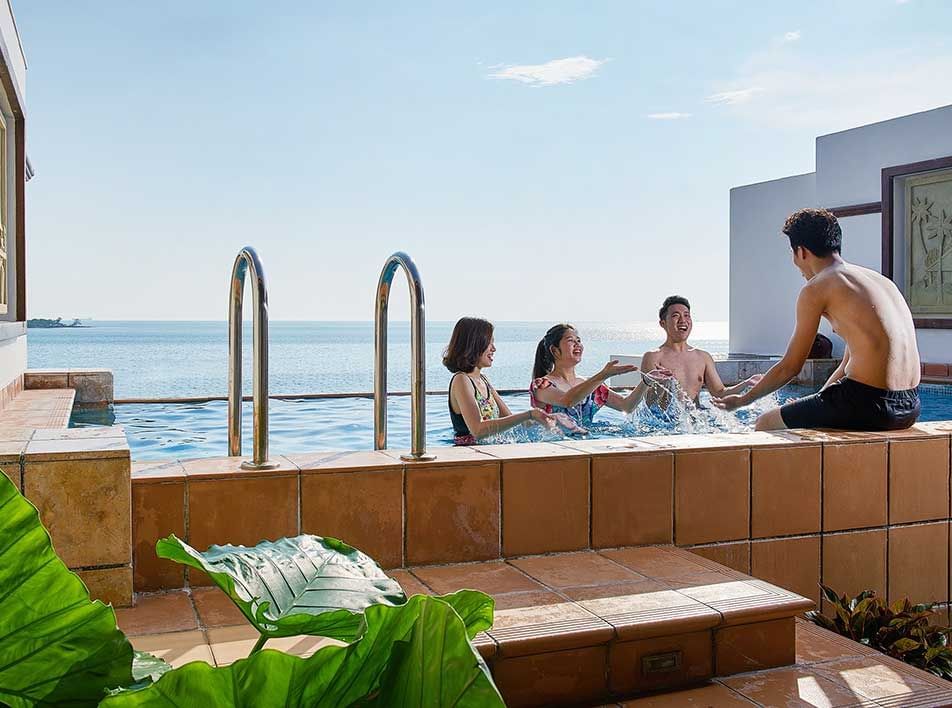 family chatting by the poolside in the indoor hotel pool - Lexis MY