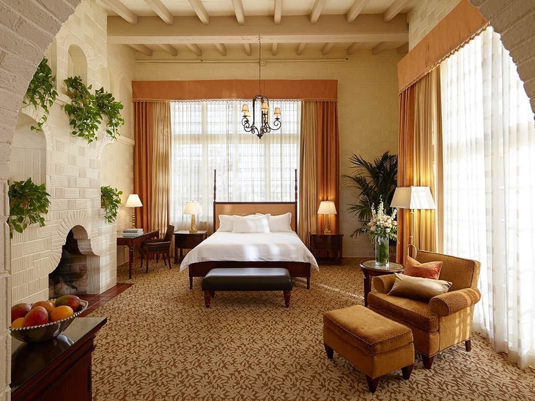 room with king bed, accent chair and fireplace