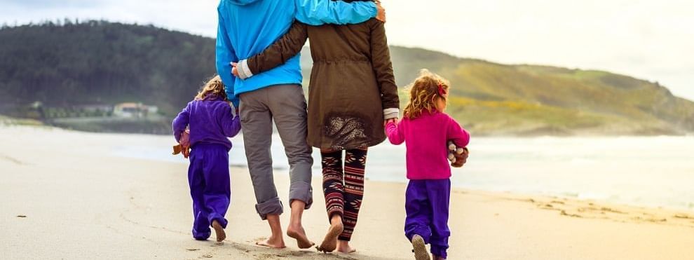 Family is walking on sandy beach near Daydream Island Resort