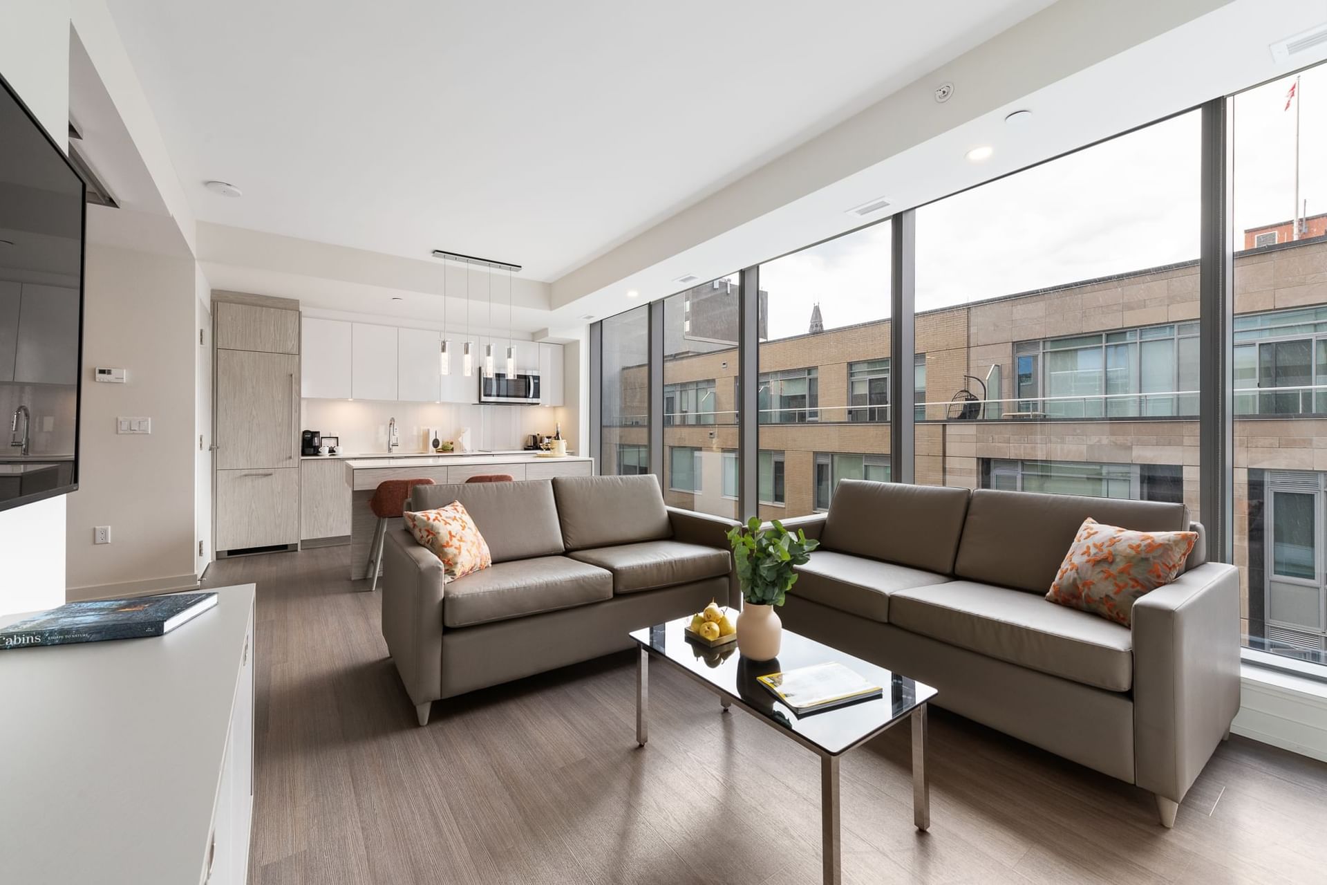 Living area with kitchenette and large window in Two-Bedroom Suites at ReStays Ottawa
