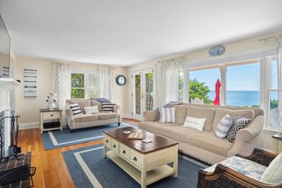 Living area with comfy sofas and carpeted floors in Eventide 4 bedroom House at Chatham Tides Resort