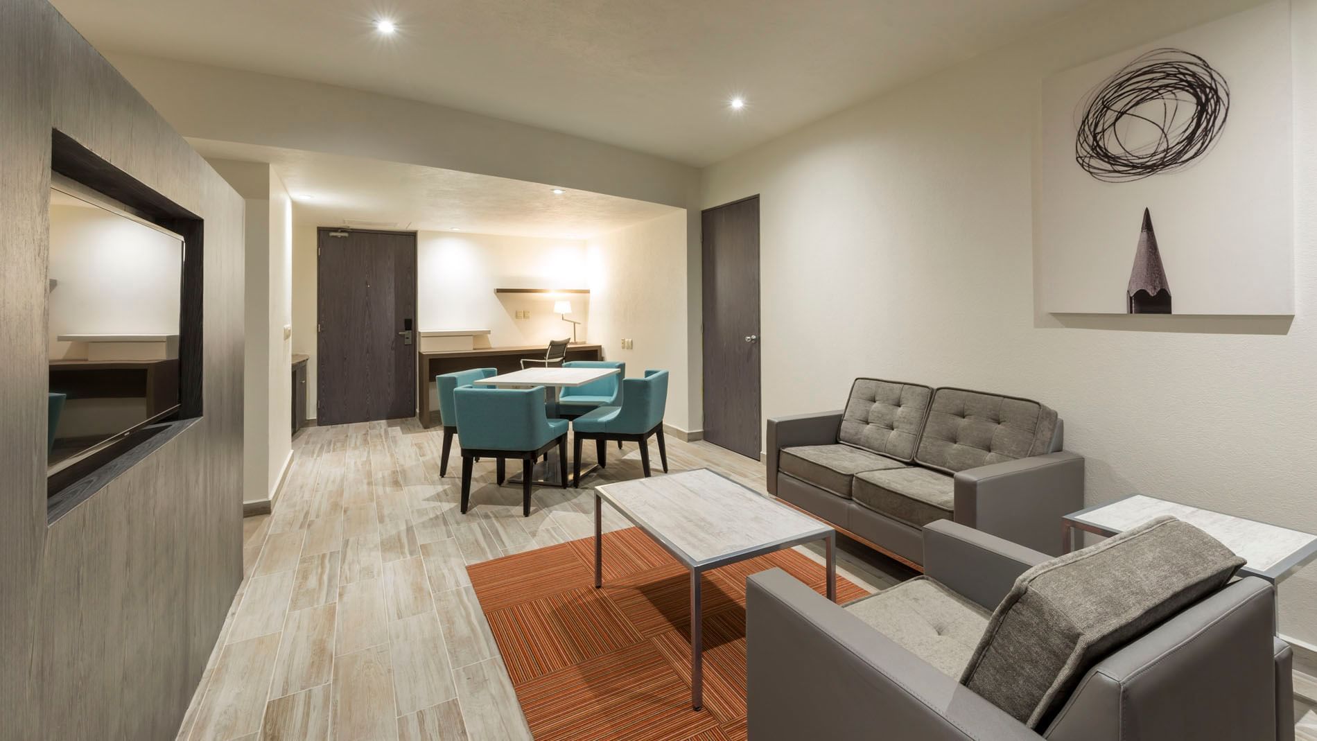 Sala de estar con sofás, mesa y comedor en Master Suite King de Real Inn San Luis Potosí.