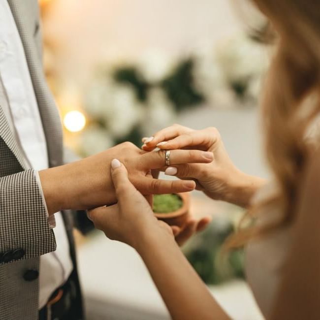 Bride and groom exchanging rings featuring our article on 