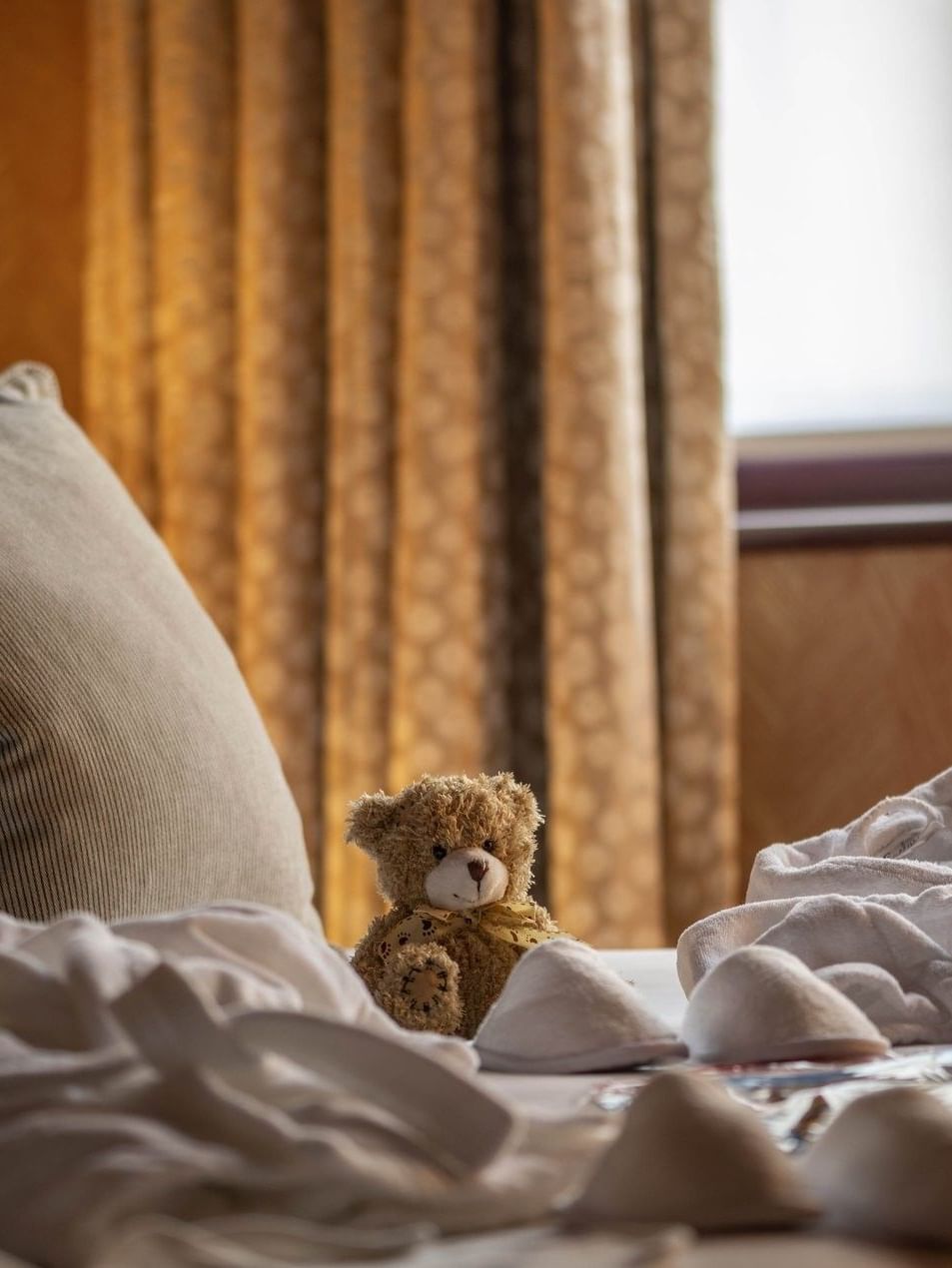 Bedroom with soft bedding and a teddy bear at The Capital Hotel, Apartments & Townhouse