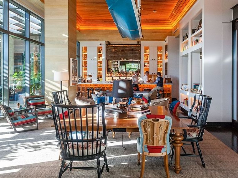 Dining area featuring a table, chairs & bar area & bright natural light in Library by the Sea on The Residences at Seafire