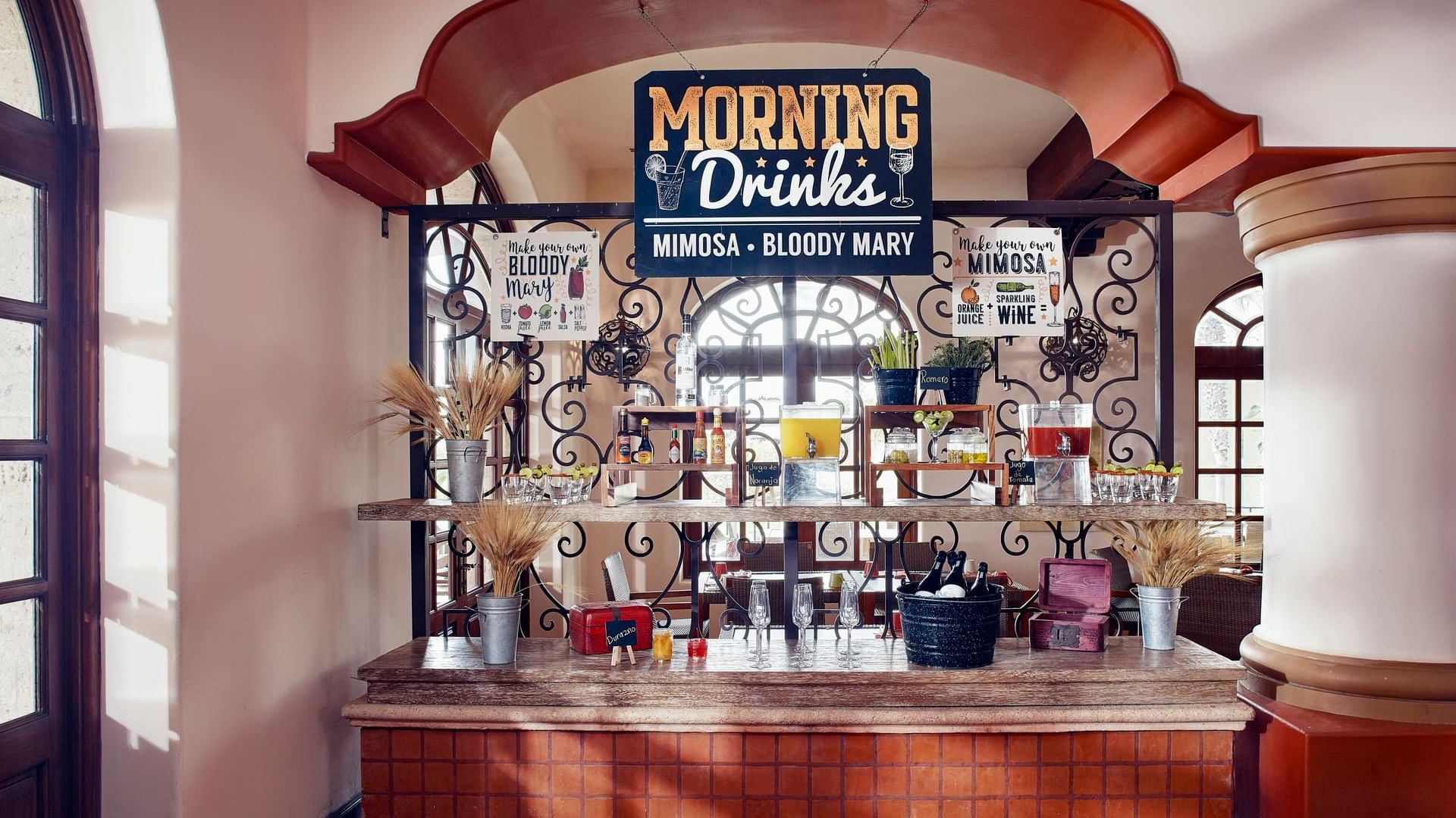 Barra de bebidas matutinas con jugos y guarniciones para mimosas en el restaurante Tomates en Hacienda Del Mar. Los Cabos