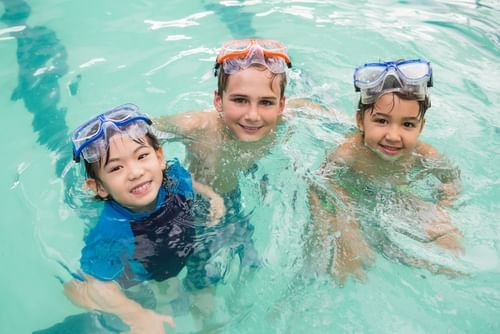 Three children having fun in the swimming pool