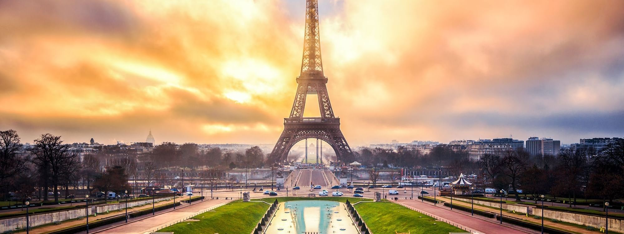 Sunrise casts a golden glow behind the Eiffel Tower near Hôtel Westminster - Paris