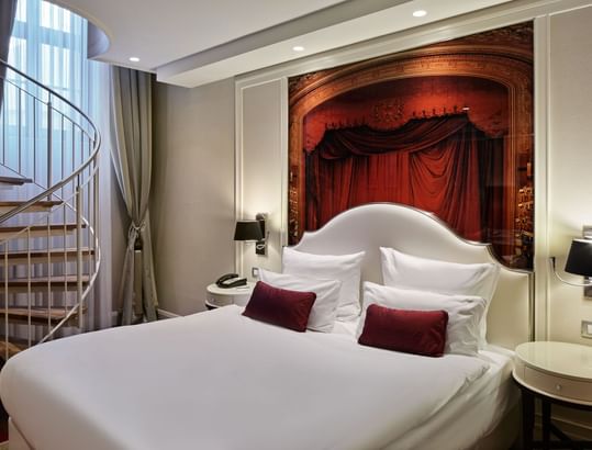 Bedroom with a spiral staircase in Junior Duplex Suite at Titanic Gendarmenmarkt Berlin