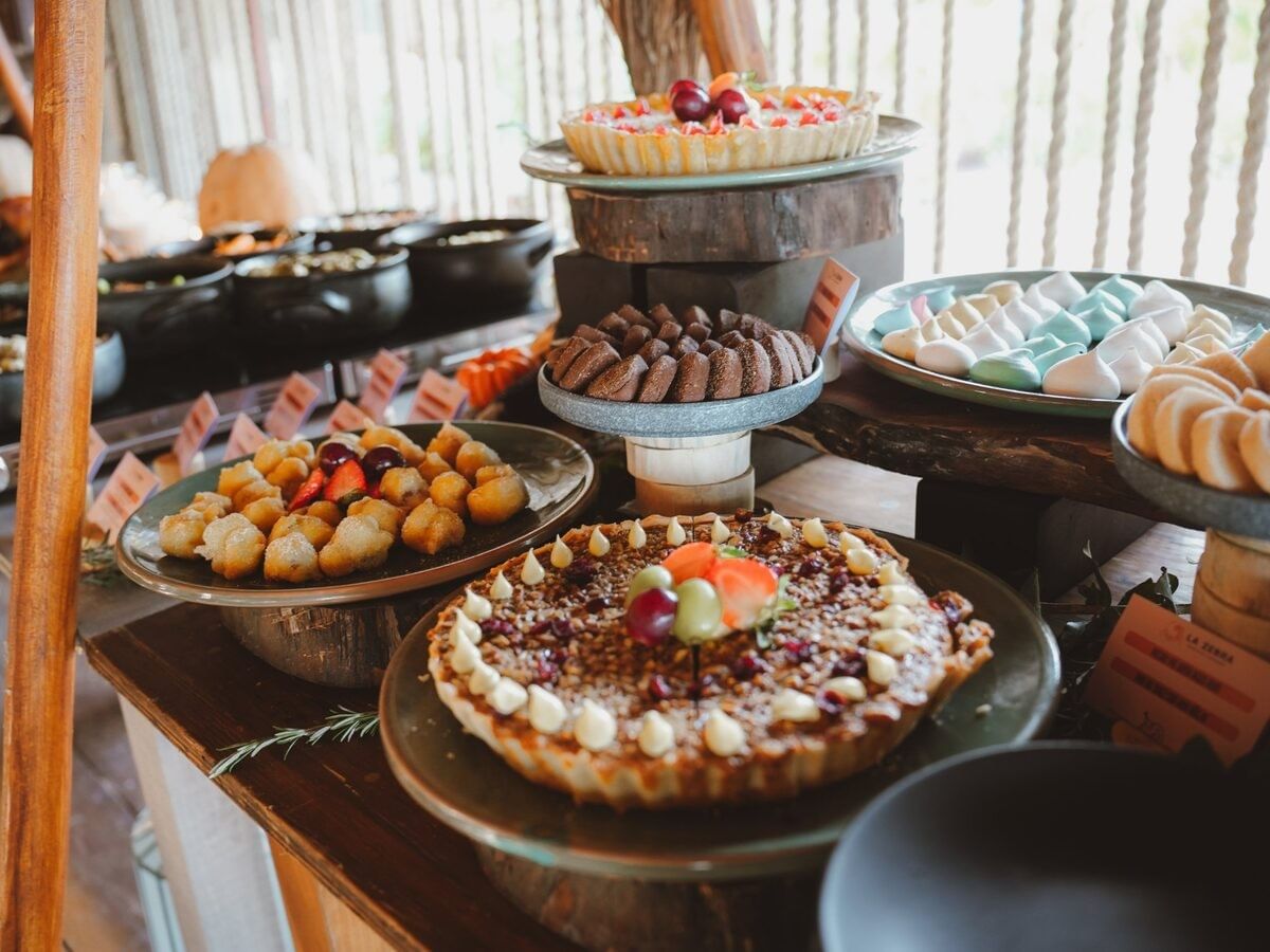 Tarts, cookies and meringues displayed on rustic dessert stands.