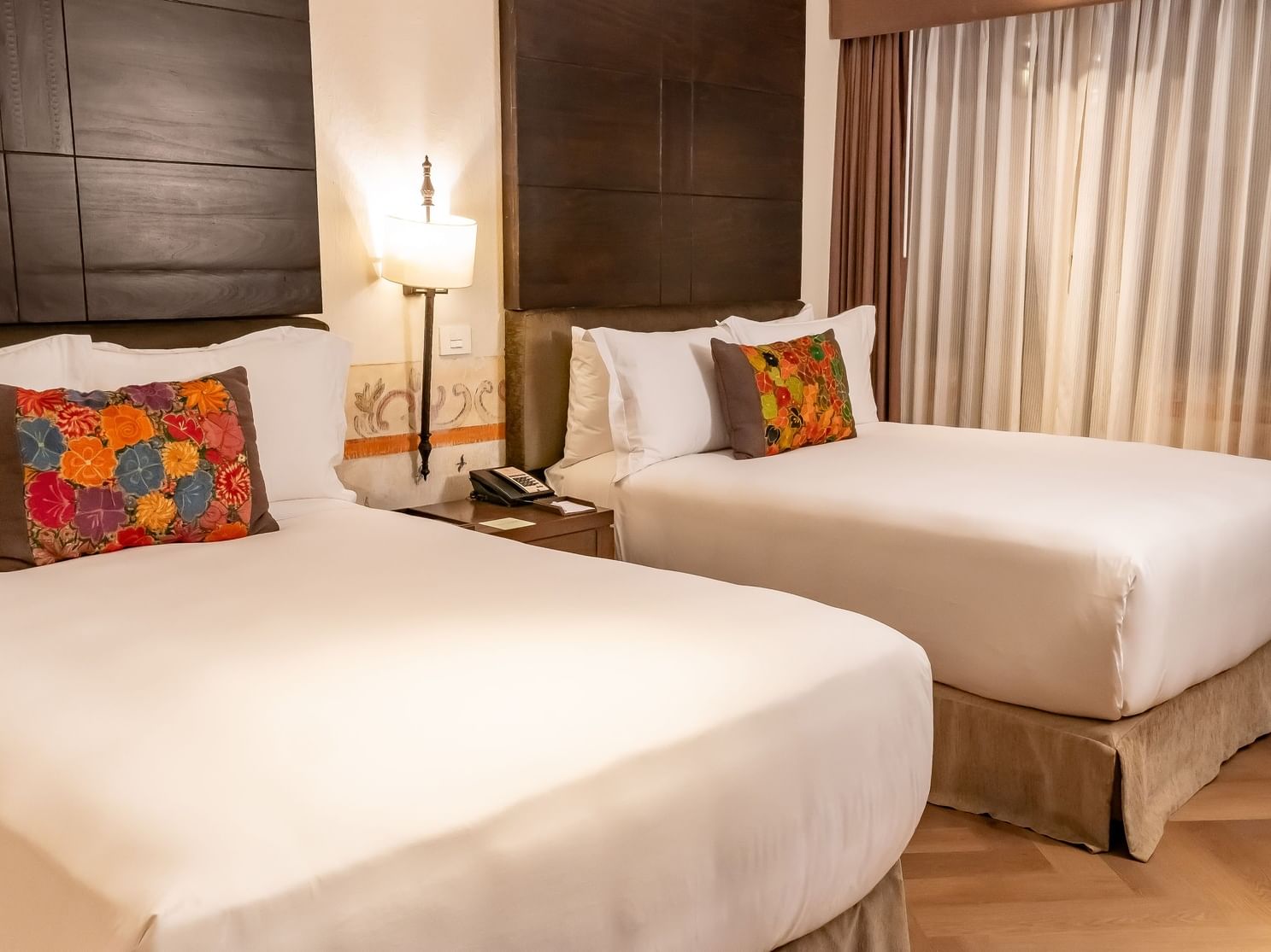 Two comfortable beds with decorative pillows in a spacious room at Quinta Real Puebla, Heroica Puebla de Zaragoza.