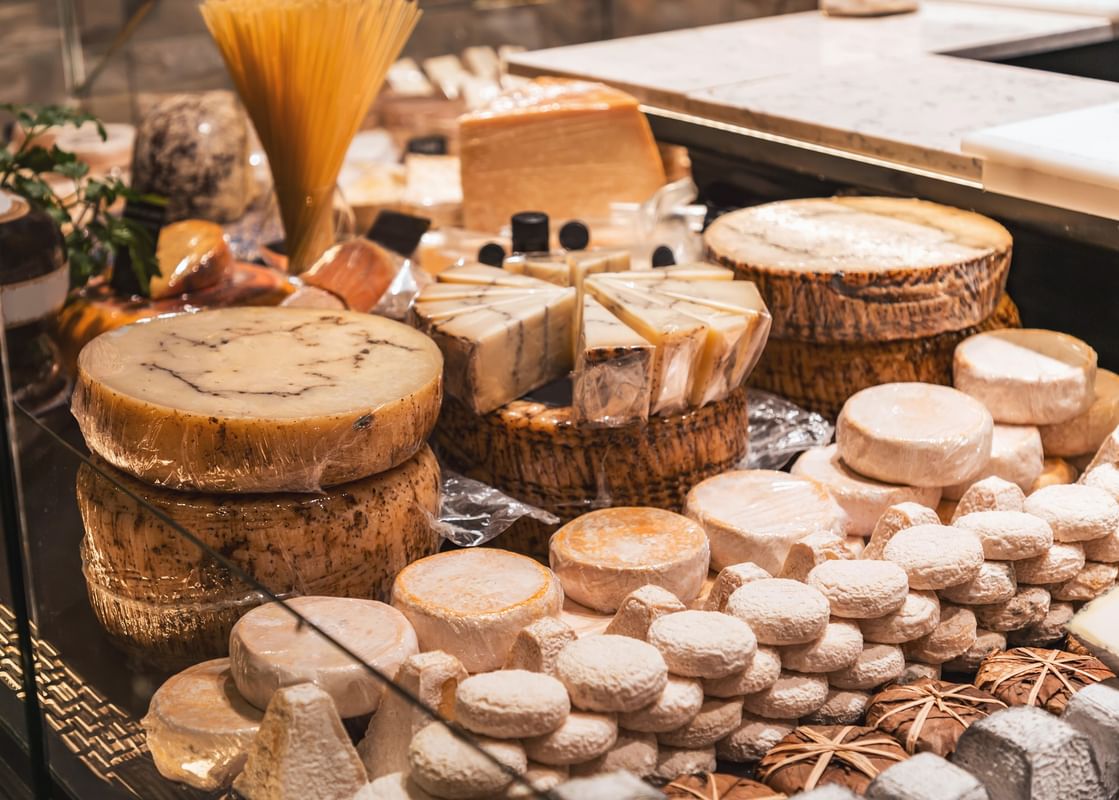 Buffet de fromages variés avec meules et portions disposées sur un plateau au Warwick Reine Astrid-Lyon