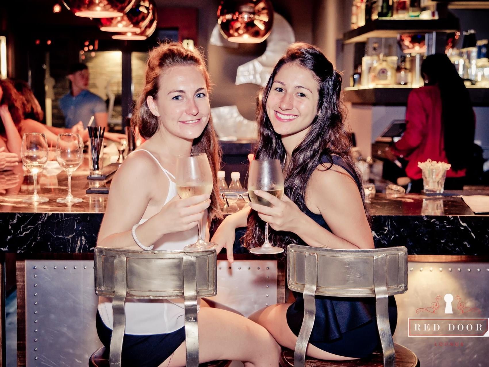 2 ladies having champagne in a bar near Bougainvillea Barbados