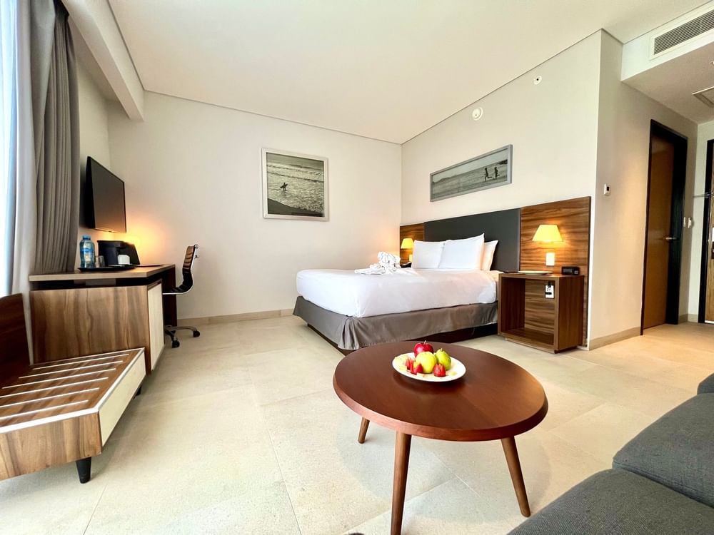 Stylish Junior Suite Queen at Fiesta Inn Express Cancún Cumbres with a round coffee table, fresh fruit, and a sitting area