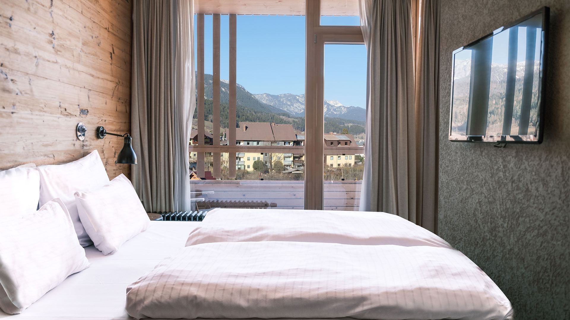 Bed & mountain view in Junior Suite at Falkensteiner Hotels