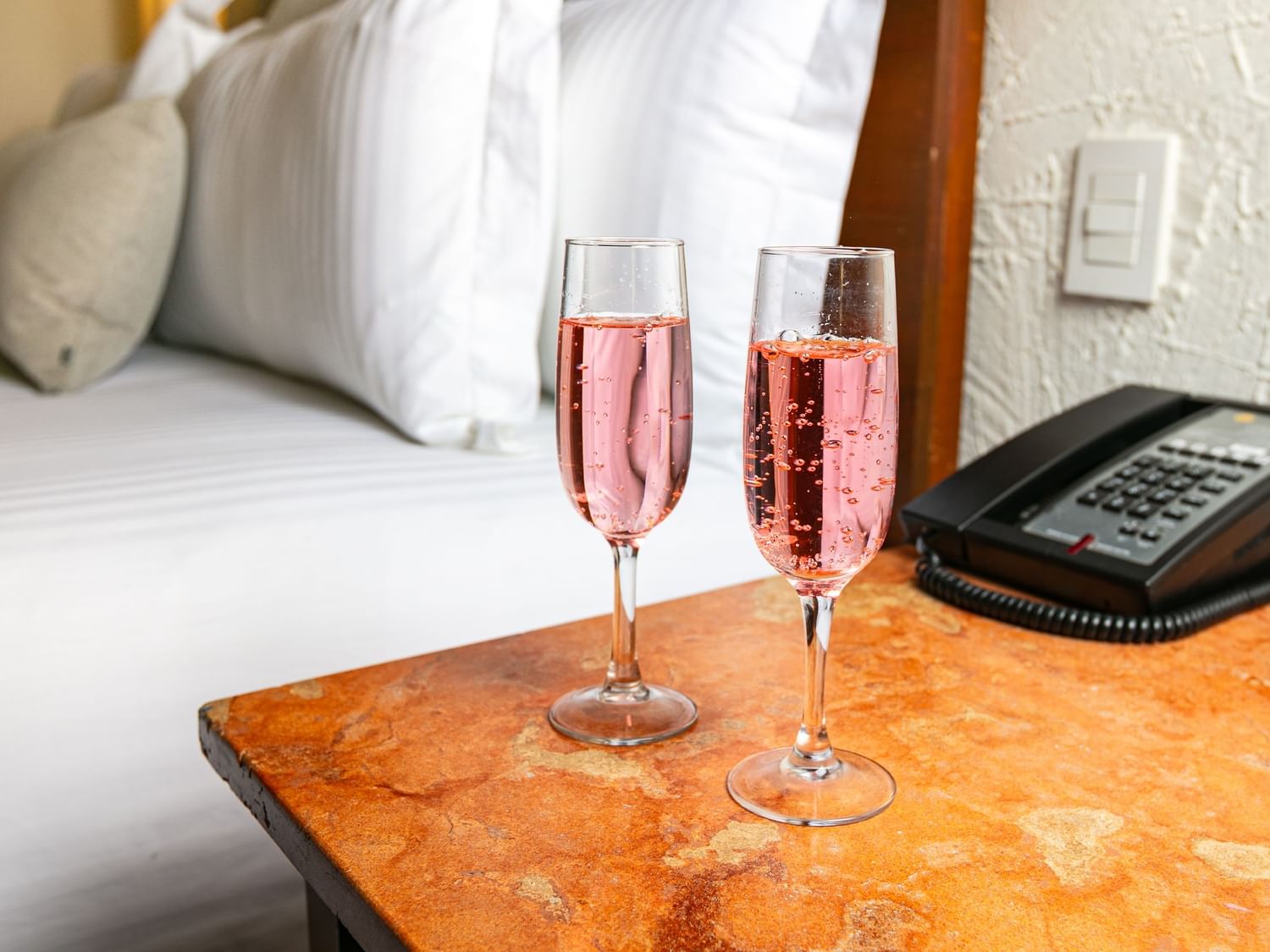 Two glasses of champagne on a table with a phone at Camino Real Guadalajara in Zapopan