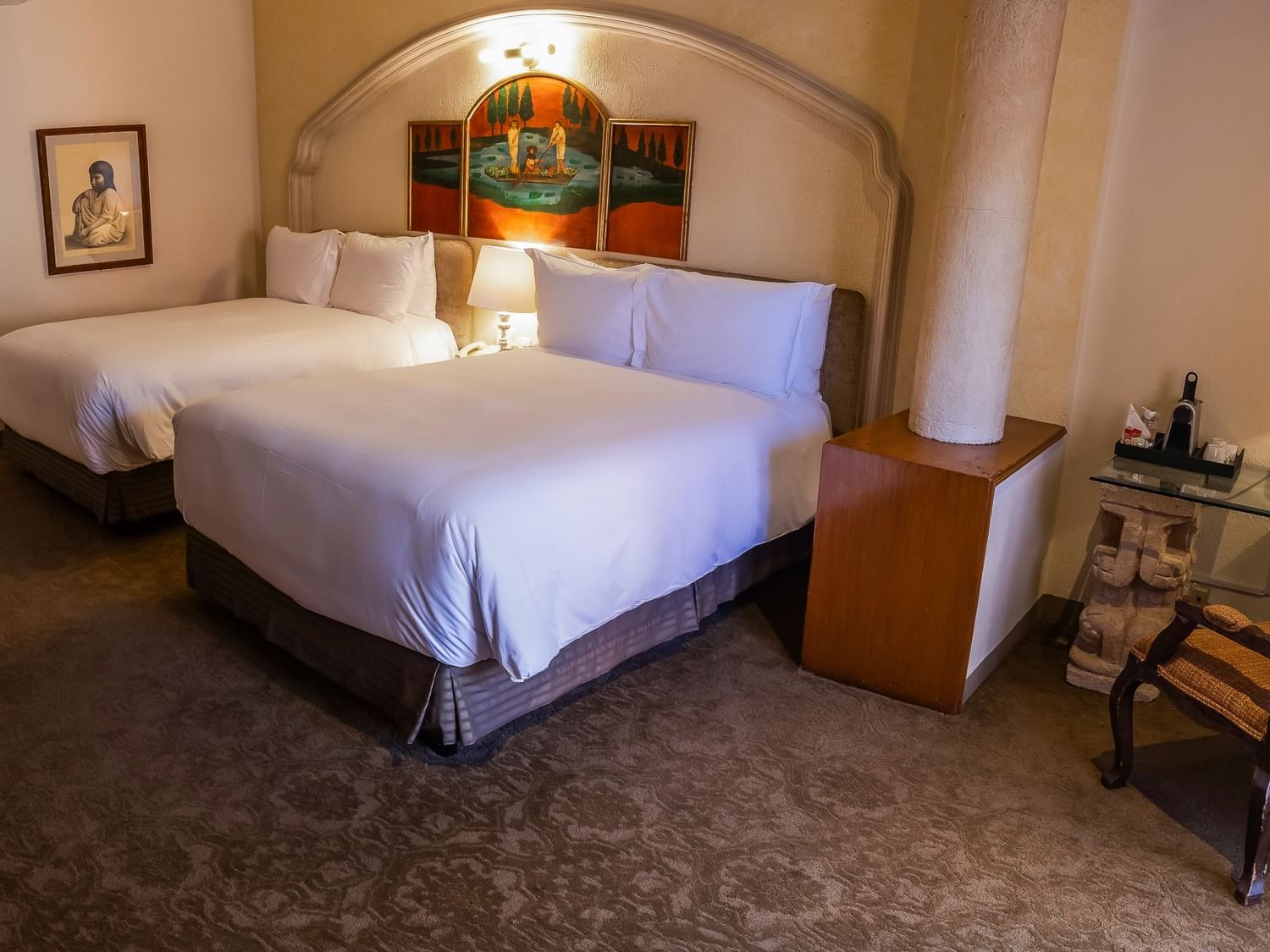 Spacious room with two double beds, arched alcove, colonial artwork, and elegant furnishings at Quinta Real Zacatecas