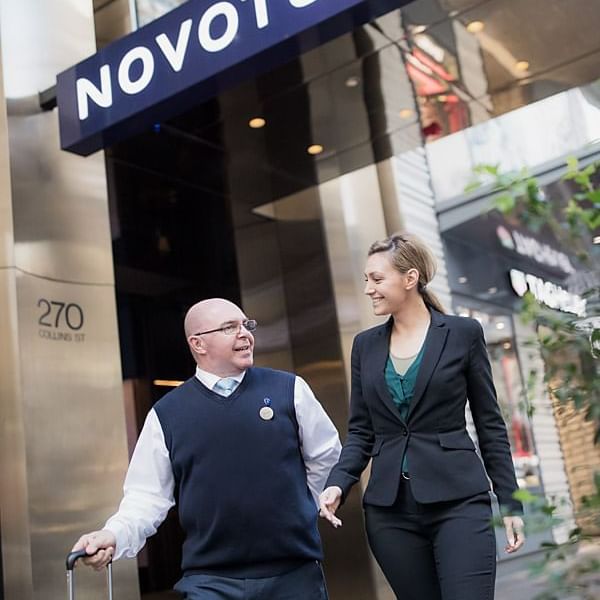 Staff posing at the entrance of Novotel Melbourne on Collins