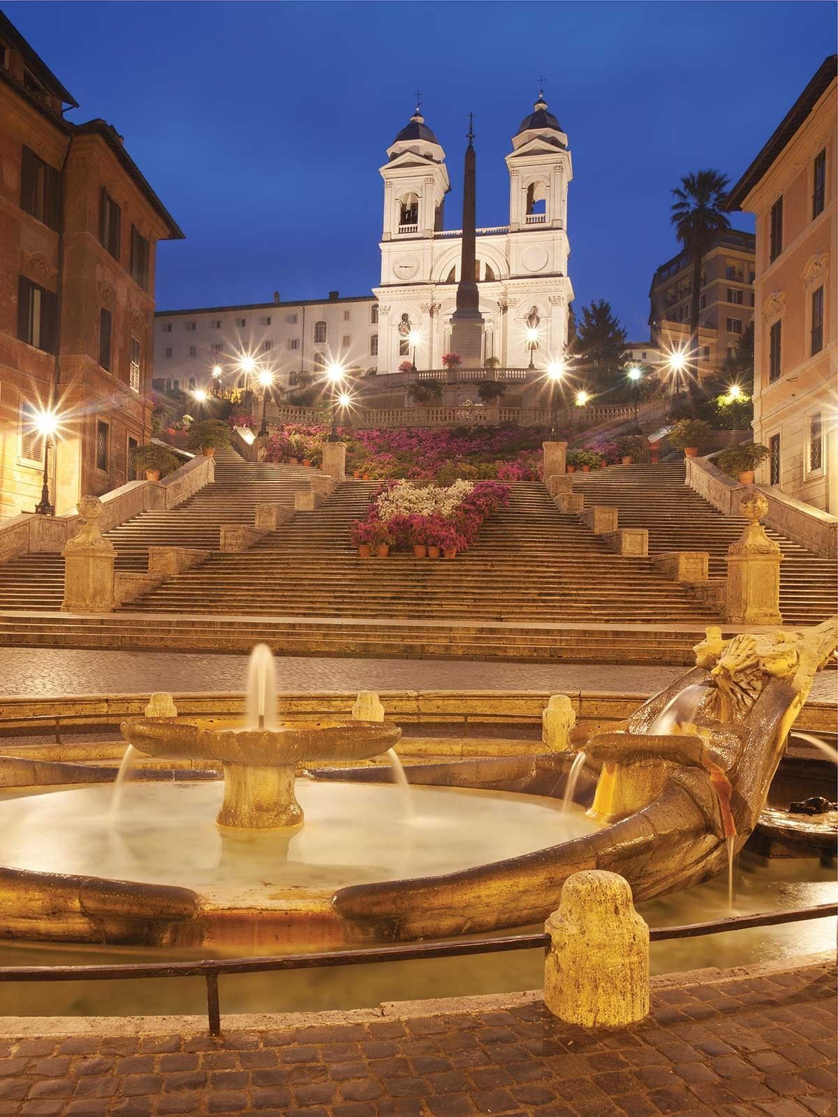 The Spanish Steps and Barcaccia fountain are beautifully lit at night, a romantic landmark near Rome Luxury Suites