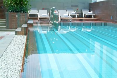 Pool area with sunbeds at Amora Neoluxe Hotel Bangkok