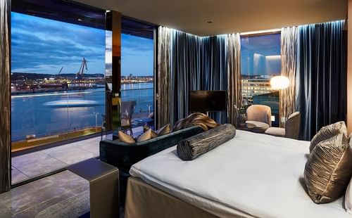 Luxurious penthouse room at Hotel Riverton with modern decor and panoramic waterfront views of Gothenburg