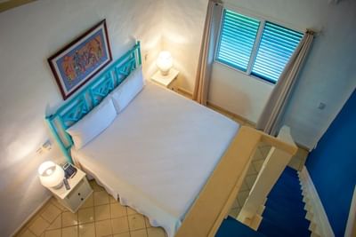 Elevated view of a bright Superior Room at La Casita by the Hub, a welcoming hotel in Bayahibe, with a blue bed