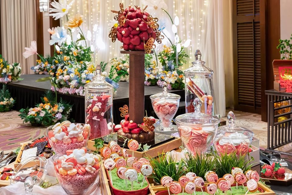 A table featuring an array of candies and a bouquet of flowers at Paradox Singapore