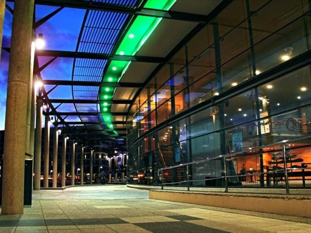 Mandurah Performing Arts Centre at night, lit with bright green and blue lights near The Sebel Mandurah