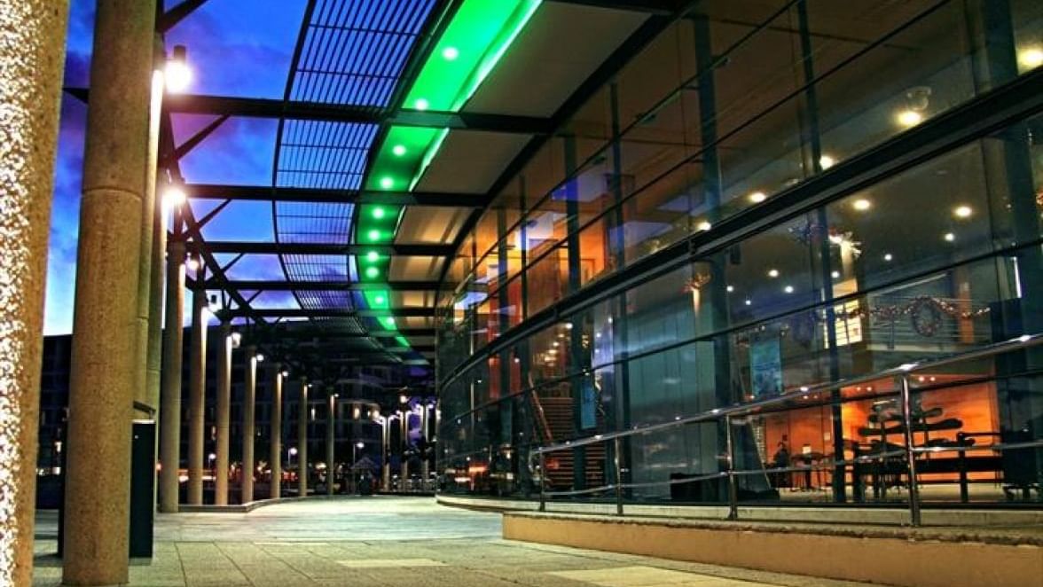 Mandurah Performing Arts Centre at night, lit with bright green and blue lights near The Sebel Mandurah