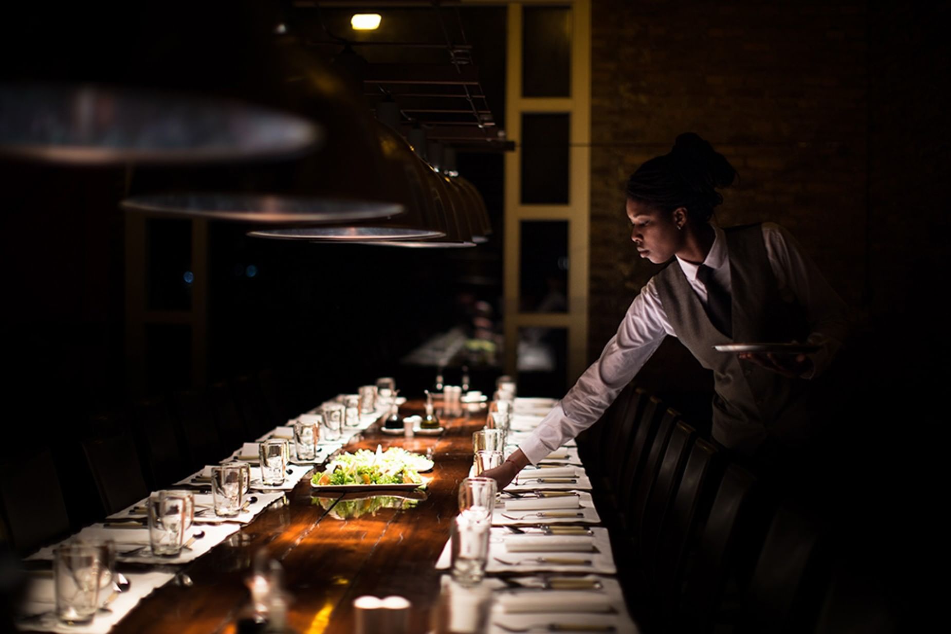 Waiter arranging a dining table in Asador at Singular Patagonia
