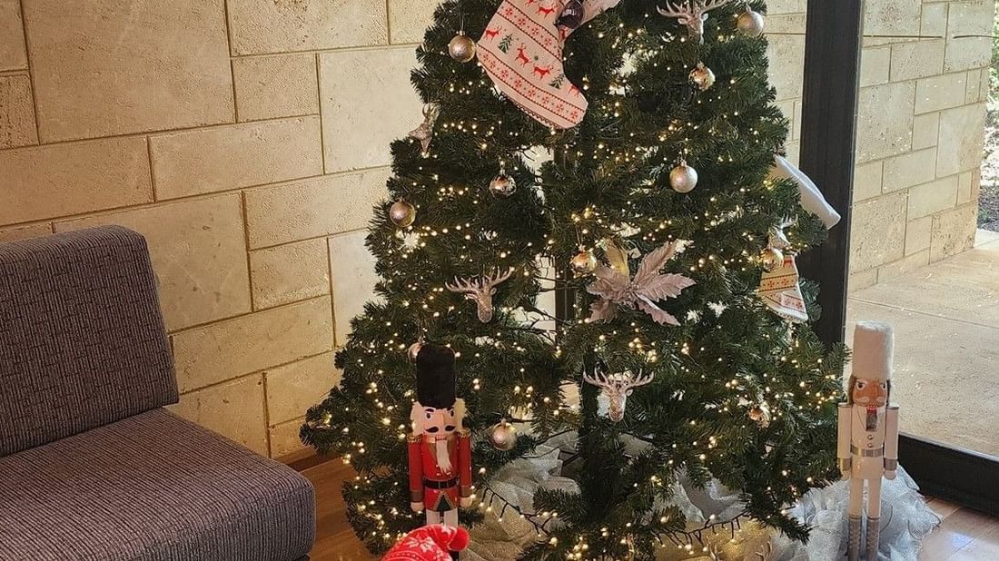 Decorated Christmas tree and festive decorations on a table showcasing Festive In-Villa Indulgence.