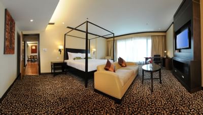 TV & couch facing king bed in a Suite at MiCasa All Suite Hotel KL