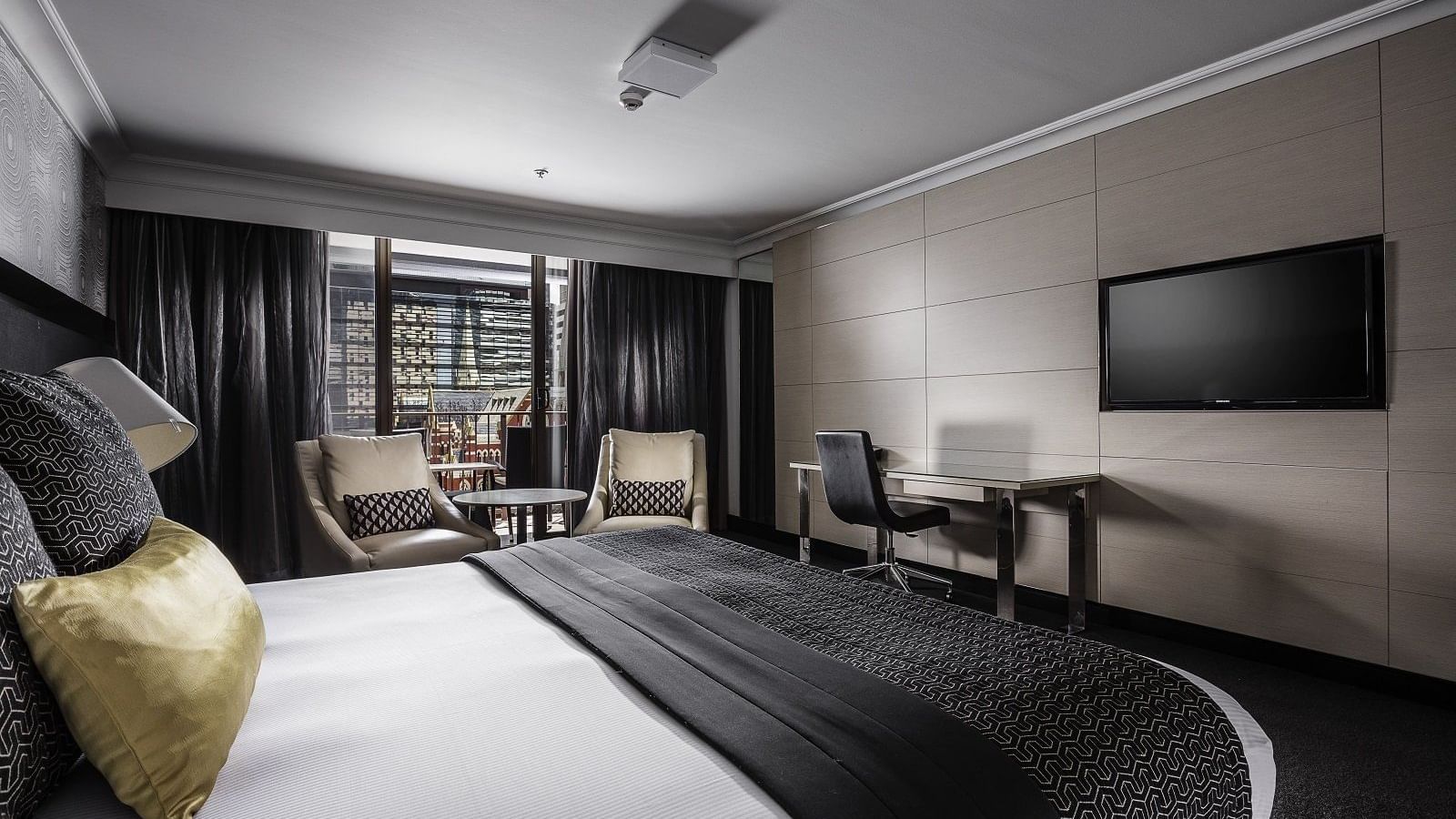 Luxurious Deluxe Balcony Room boasting a plush king bed and seating area at Pullman Brisbane King George Square