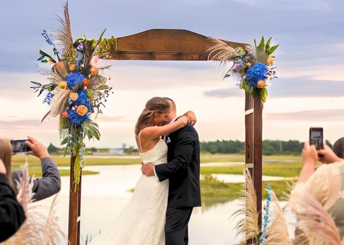 A couple hugging each other on the outdoor wedding floor at Ogunquit Collection