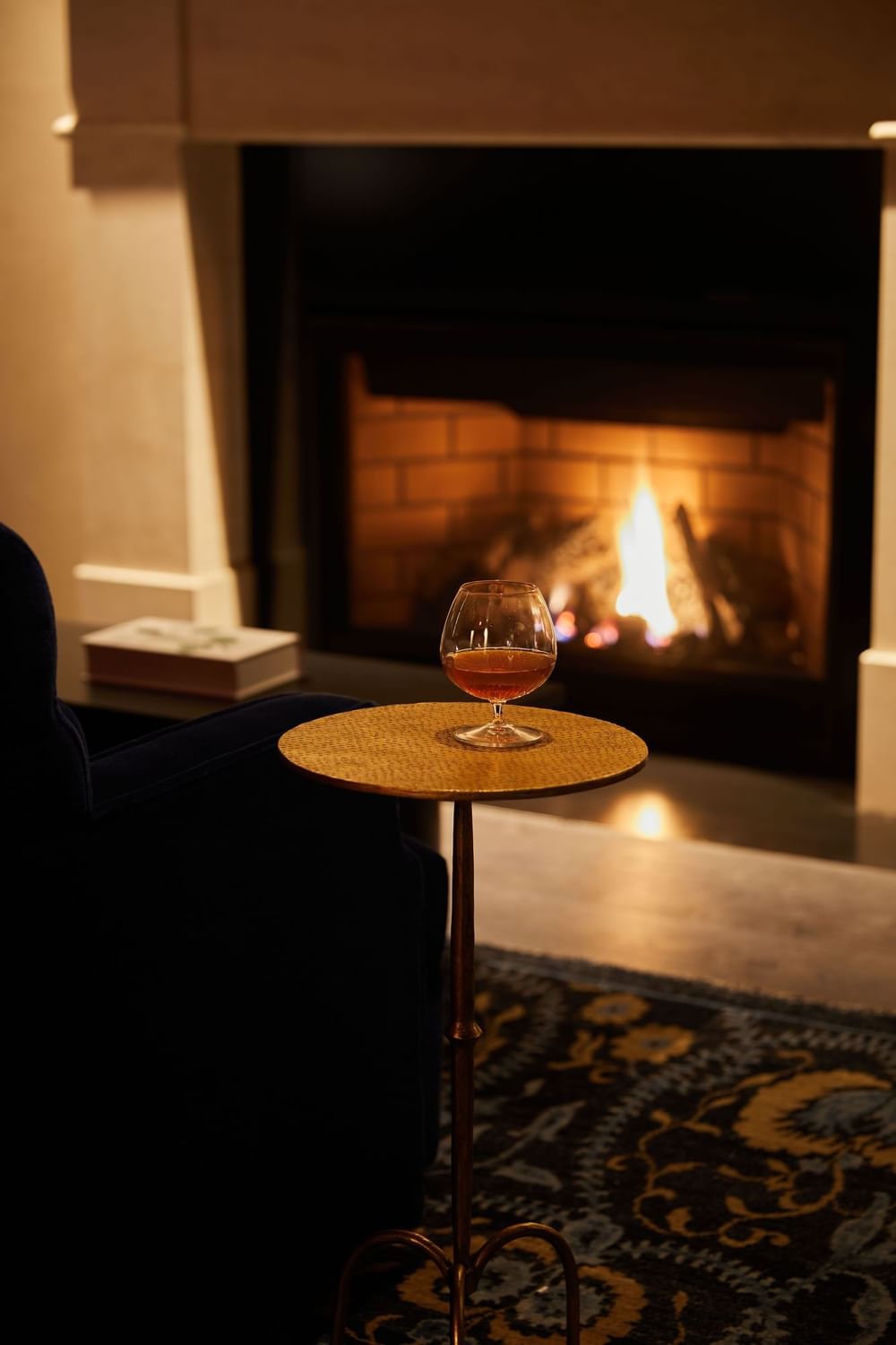 Close-up of a warm drink on a small table near a crackling fireplace at El Prado Hotel