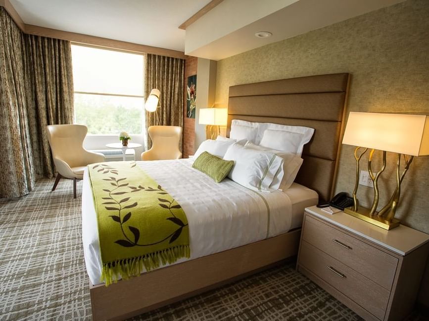 a bed and two chairs in a hotel room